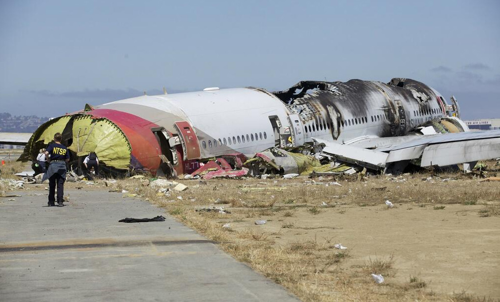 The wreckage of Asiana Airlines flight 214 at San Francisco International Airport in July 2013. The aircraft struck a sea wall on approach. The mostly aluminum Boeing 777-200ER presents a notably different burn pattern than was seen with the JAL A350-900 at Haneda. All but two passengers survived after injuries sustained as a direct result of the crash.