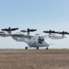 A white Vertical Aerospace VX4 eVTOL prototype sits on a paved surface against a pale blue sky