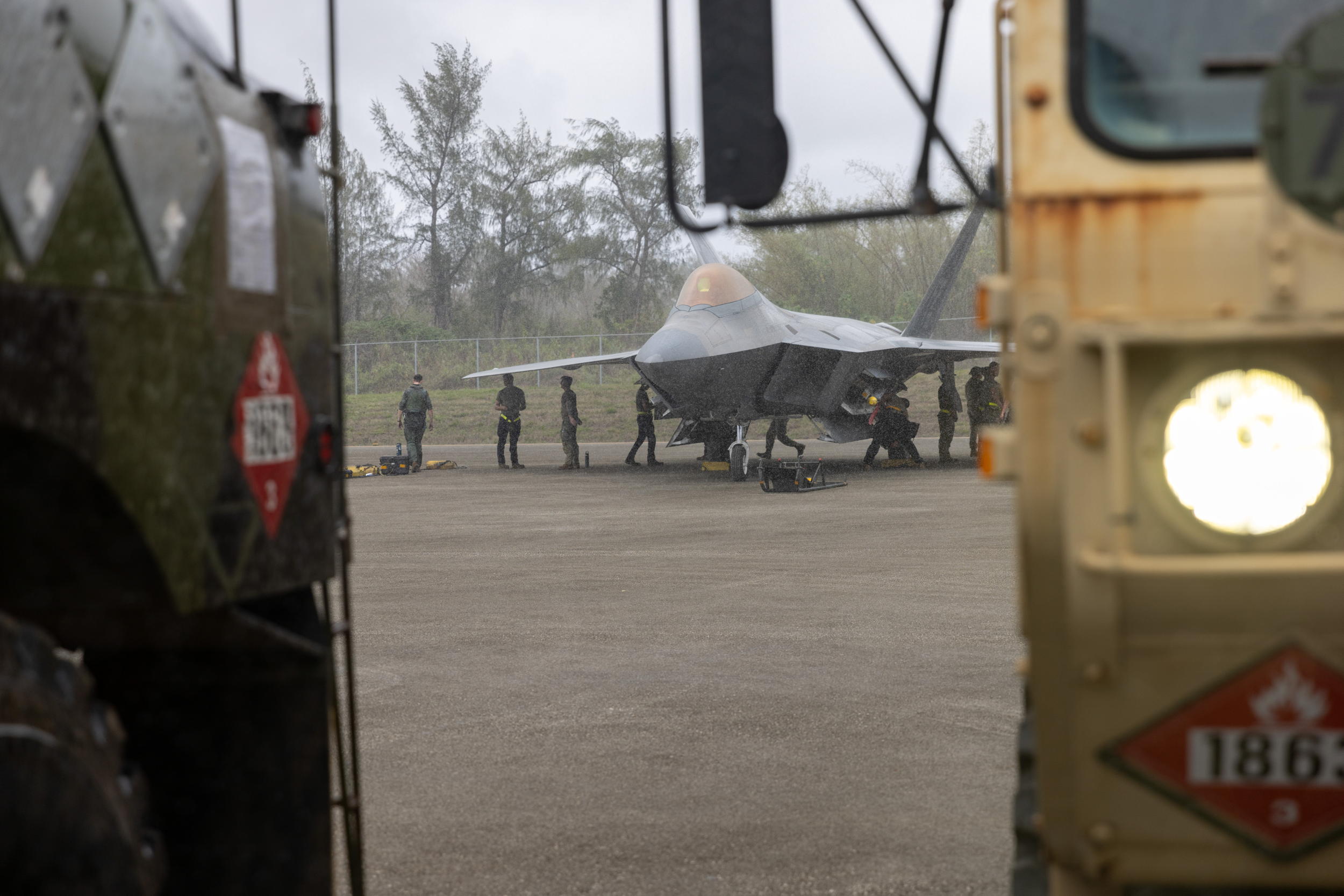 U.S. Air Force Airmen assigned to the 27th Fighter Squadron, 1st Fighter Wing, perform maintenance checks on one of their F-22 Raptors amid joint refueling operations with the U.S. Army in support of Valiant Shield 24 at the Tinian International Airport, Tinian, Northern Mariana Islands, June 11, 2024.